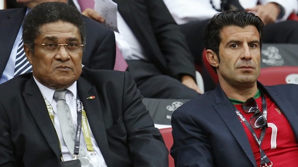 Former players Eusebio, left, and Luis Figo sit in the Warsaw stands.