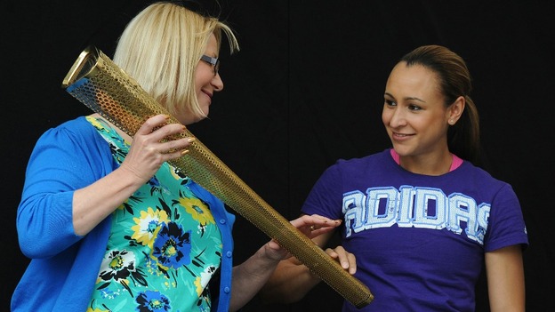 Jessica Ennis touches the Olympic Torch held by Tina English during a civic send-off event in Sheffield city centre