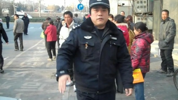 A police officer prevents ITV News from filming the protest