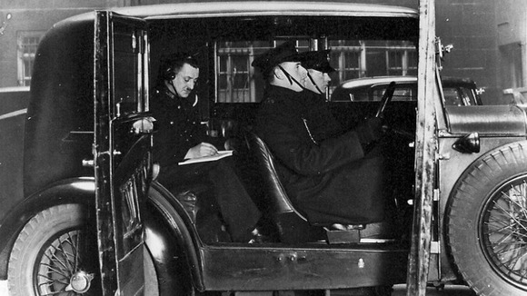 Officers in an early wireless car, receiving a Morse Code message from the Information Room.