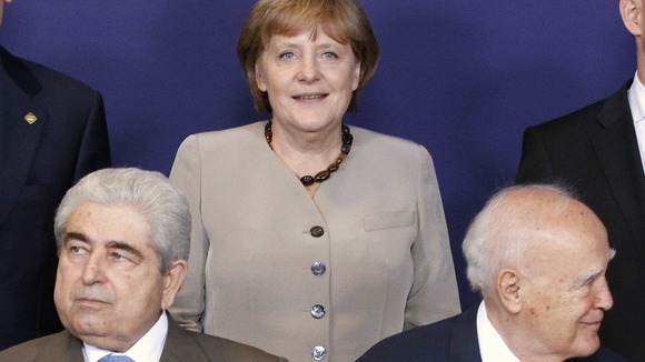 Cyprus' President Demetris Christofias and Greece's President Karolos Papoulias and Angela Merkel