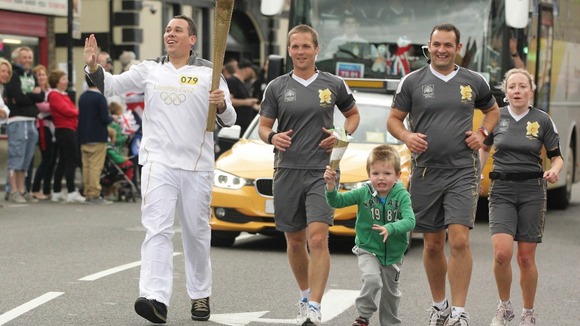 The young boy attempts to join torchbearer Alexander McCann