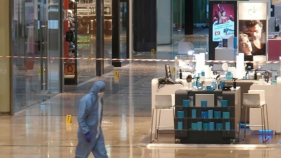 A forensics officer attends the scene at Westfield in Stratford, east London, after a man was stabbed to death