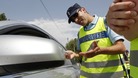 A French Gendarme distributes chemical breath testers which measure the level of alcohol in the breath