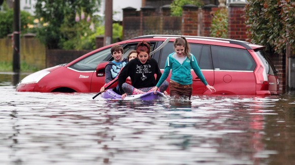Locals making their way in a boat along a flooded road in Felpham near Bognor Regis in West Sussex.
