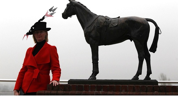 A female racegoer during day two of the 2012 Cheltenham Festival poses next to a horse