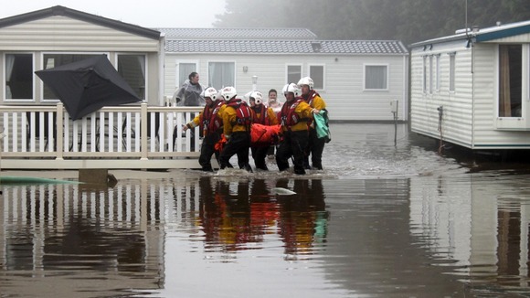 Volunteers from Filey RNLI lifeboat station and the coastguard helping to rescue people from their caravans.