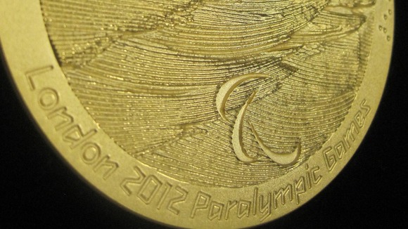 A 2012 Paralympics gold medal, which has text written in standard and braille writing at the Royal Mint in Llanstrisant.