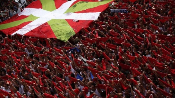 The Basque Country flag is held up by visitors to the San Fermin festival.