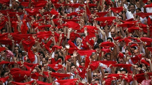 Revellers hold up their red scarves at the start of the festival.