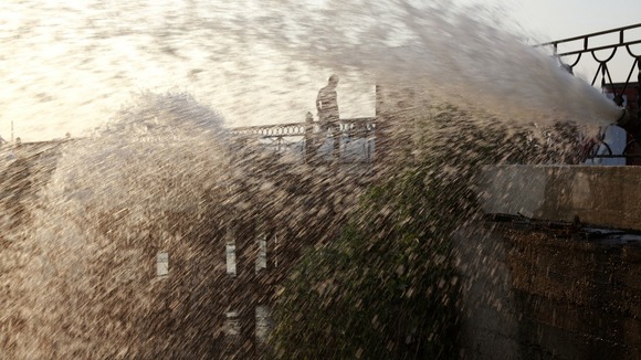 Water streams out of a hose placed to dewater the flooded town of Krymsk