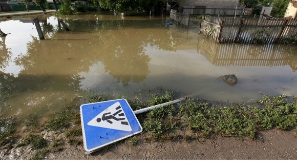 A traffic sign lays on the ground in a flooded street in the town of Krymsk in Krasnodar region