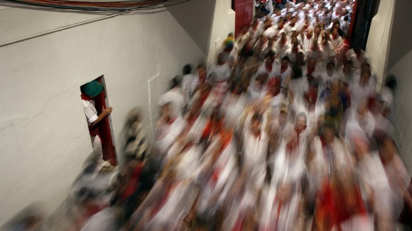 Runners enter the bullring during the third running of the bulls of the San Fermin festival in Pamplona