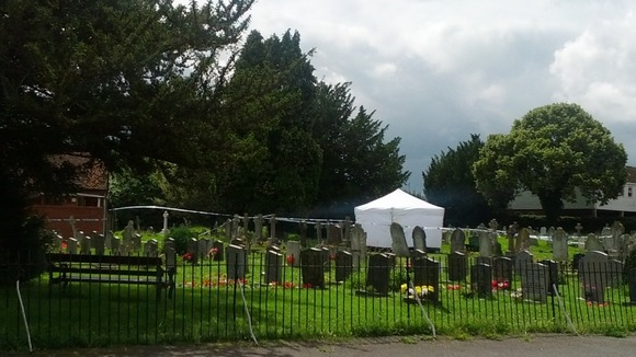 A white tent in a church yard in Writtle, Essex where the body of a man suspected of shooting an off-duty police officer was found.