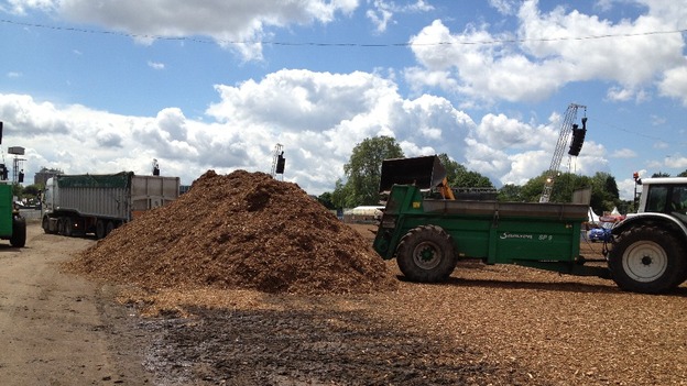Tractors move wood chippings around the site.