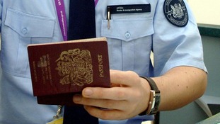 A member of the Border Force checks a passport.