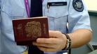 A member of the Border Force checks a passport.