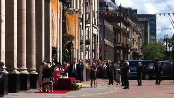 Queen signing the visitors book outside the Council House
