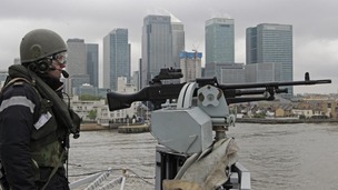 A member of the Royal Navy mans a gun at the bow of HMS Ocean.
