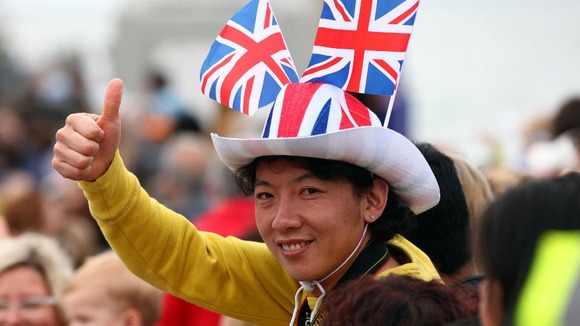 A spectator cheering on the Olympic Flame on the Torch Relay leg through Bournemouth
