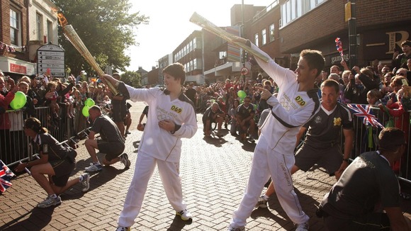 Torchbearers Samuel Smith and Christopher Smith imitating Usain Bolt's celebration whilst carrying the Olympic Flame