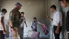 A resident in Tremseh shows an UN observer blood stained items in a house