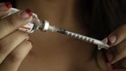 A woman prepares an injection 