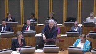 Carwyn Jones answering questions from party leaders.