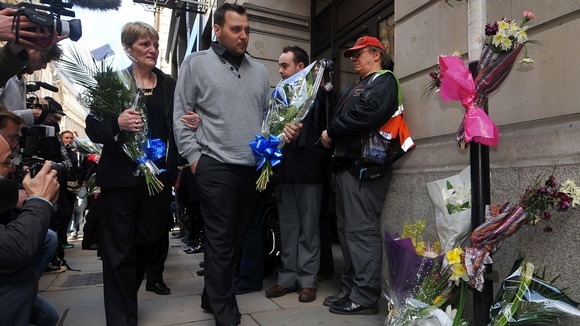 Ian Tomlinson's widow Julia Tomlinson (left) and stepson Paul King, arrive with flowers at a memorial in London.