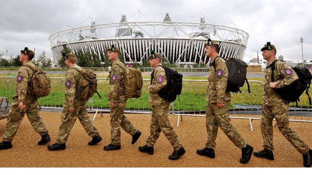 Group of soldiers from the Royal Regiment of Scotland march in front of the Olympic stadium