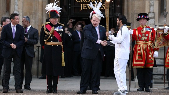 Abul Kasam shaking hands with Mayor of London Boris Johnson as he holds the Olympic flame
