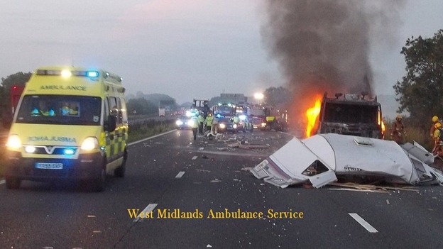 The lorry on fire after the collision between the lorry and a car towing the caravan on the M6