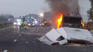 The lorry on fire after the collision between the lorry and a car towing the caravan on the M6