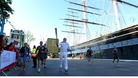 Robin Knox-Johnston, the first person to sail non-stop around the world, runs the torch around Cutty Sark. 