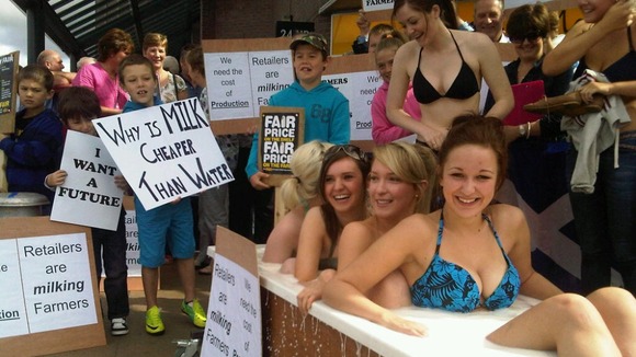Dairy farmers and girls in bath of milk