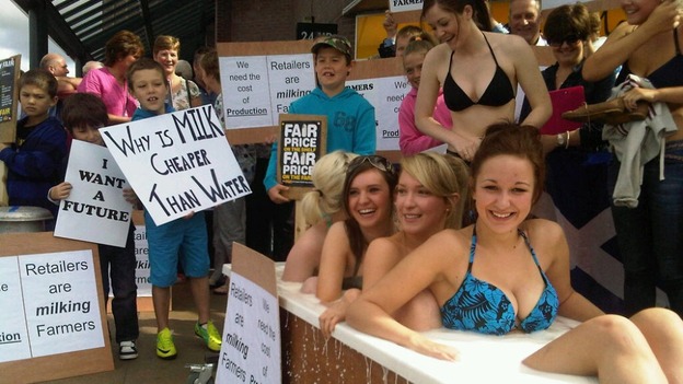 Dairy farmers and girls in bath of milk