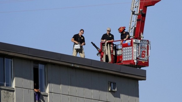 Police on a roof top across from Holmes' apartment in Colorado
