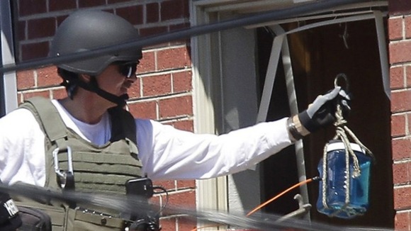 Officers put a container filled with blue liquid to use in the explosion
