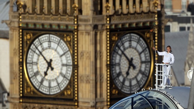 Amelia Hempleman-Adams poses with the Olympic Flame on top of a London Eye pod, with Big Ben behind her.