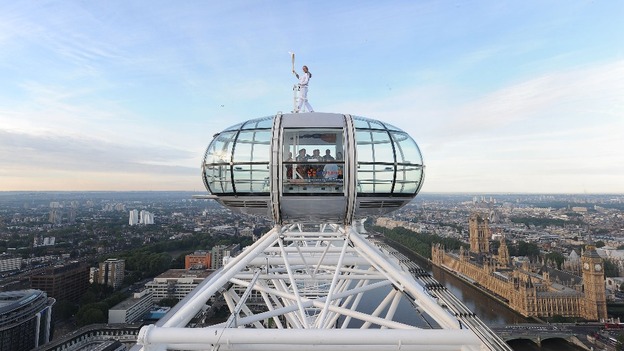 Amelia Hempleman-Adams poses with the Olympic Flame on top of a London Eye pod on the Torch Relay leg through London.