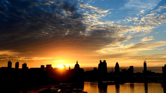 The sun rises over St Paul's Cathedral, London.