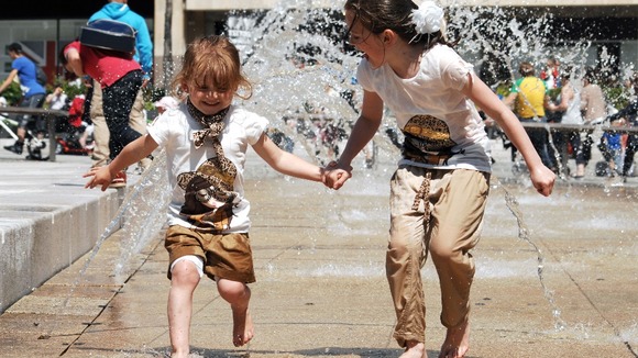 Sisters Ella (right) , aged eight, and Lilly, aged four, run through the fountains in Nottingham's Old Market Square.