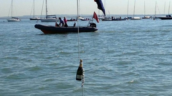 A bottle of champagne hangs off a boat on the Isle of Wight as the Island prepares for the Queen