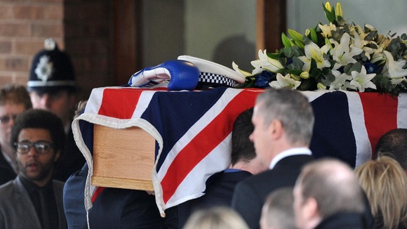 Pallbearers carrying the coffin of PC David Rathband into Stafford Crematorium