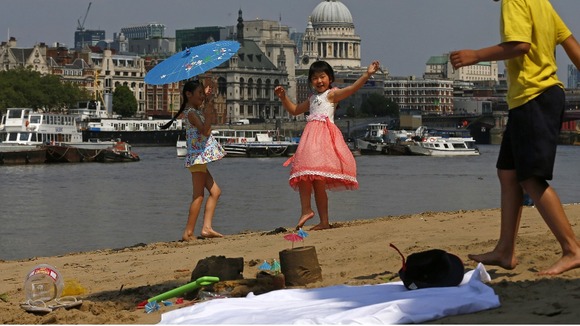 Julia Yeung and Amy Liu enjoy the hot weather on the banks of the River Thames