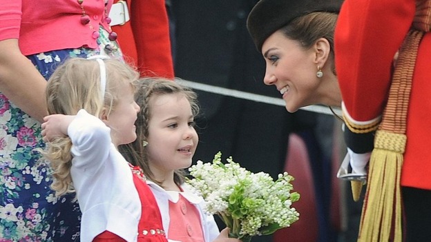 The Duchess of Cambridge talks is presented with a posy by Isabella Stevenson.