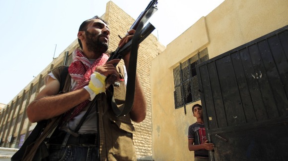 Free Syrian Army member aims his weapon after hearing shooting in Aleppo.