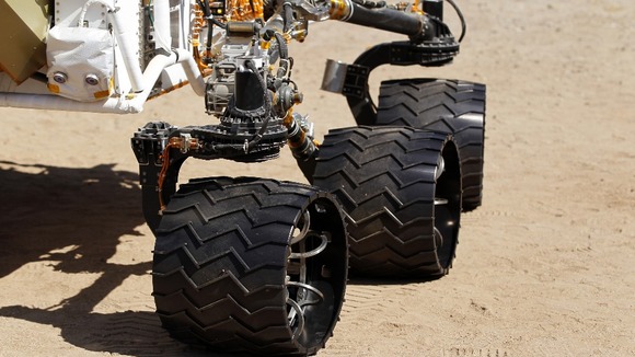 Three of six 20 inch aluminum wheels are seen on an engineering model of NASA's Curiosity Mars rover.