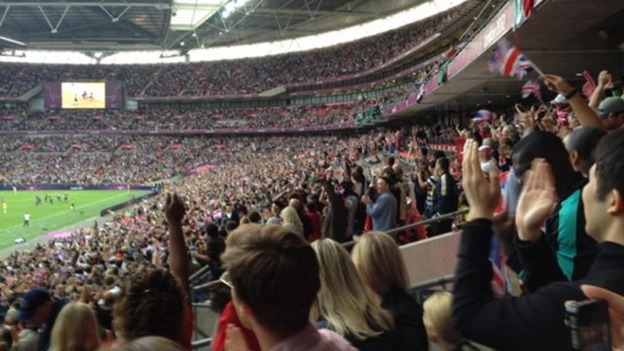 Crowds cheering on women's Team GB football team against Brazil