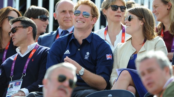 Prince Harry shares a joke with Princess Eugenie as they watch the Olympic Eventing